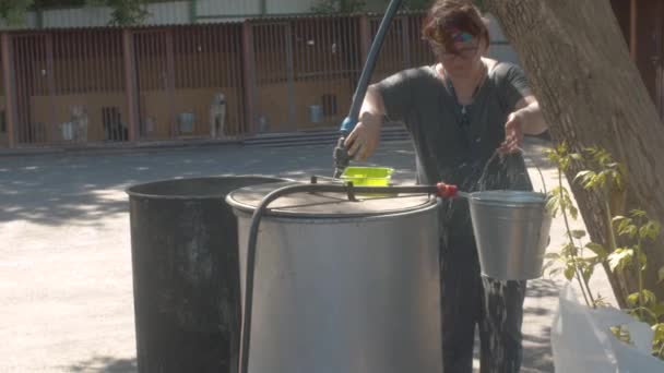 Женщина-волонтер относит воду в ведро — стоковое видео
