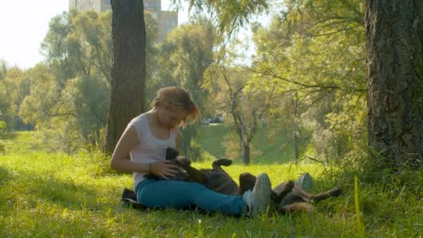 Femeia atrăgătoare și câinele ei în parc — Videoclip de stoc