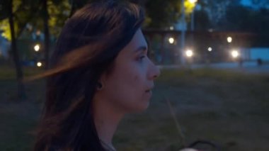 Genç bir kadın parkta yürüyor.