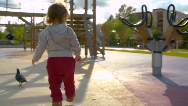 Baby girl is staggering after riding a carousel — Stock Video