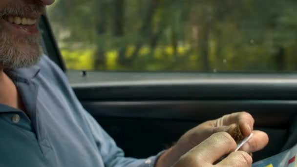 Mains d'un homme âgé tordant une cigarette — Video