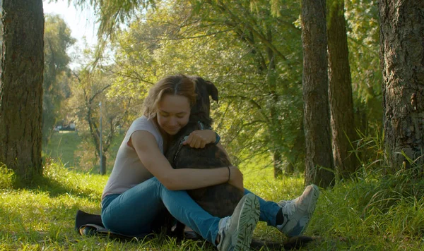 Atractiva mujer sonriente abrazando a su bonito perro —  Fotos de Stock