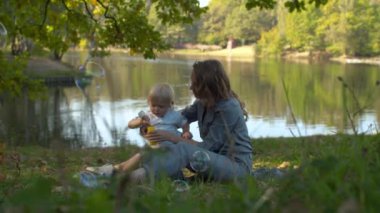 Mutlu anne ve oğlu sabun köpüğü üflüyor.