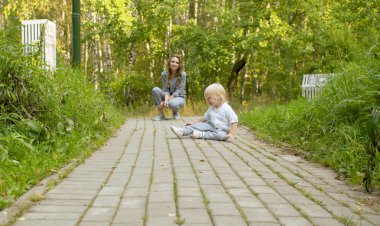 Mutsuz çocuk yolda oturuyor.