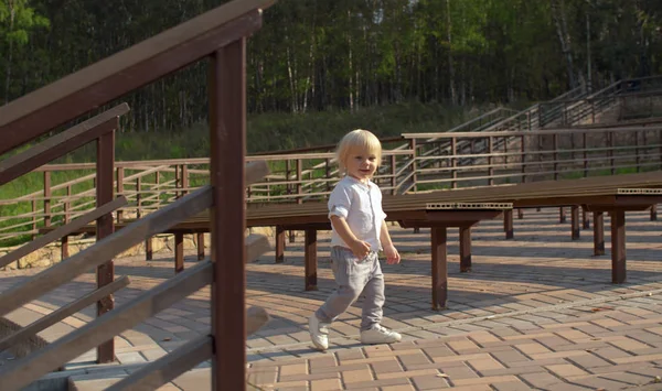 Chlapec kráčí mezi lavicemi — Stock fotografie