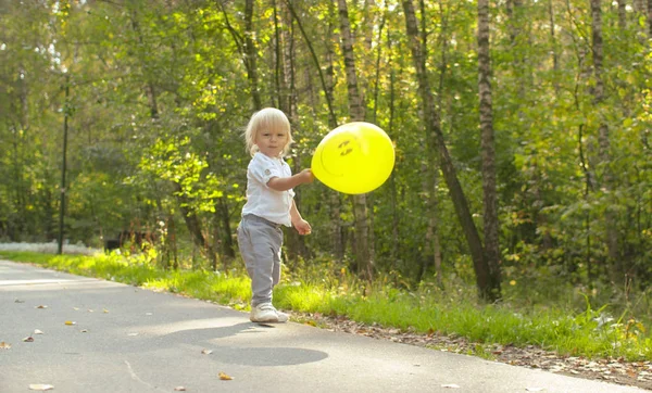 Pequeño niño divertido con globo amarillo —  Fotos de Stock