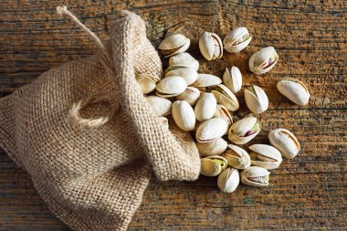 Ahşap arka planda küçük çuvalda yer fıstıkları