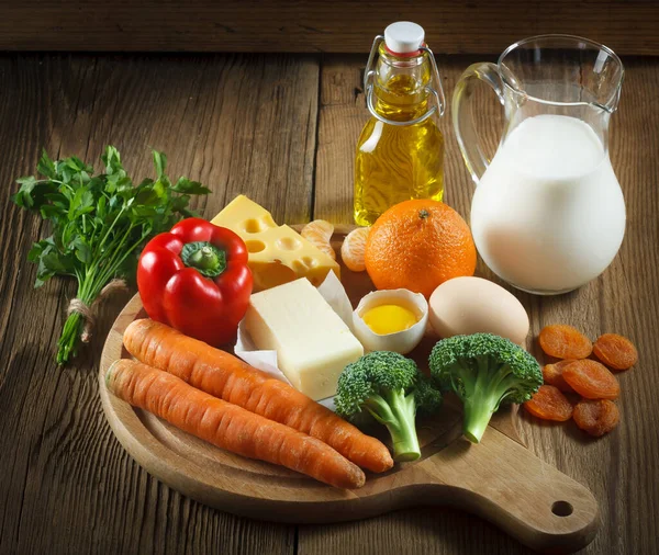 Vitamin A in food. Natural products rich in vitamin A as tangerine, red pepper, parsley leaves, dried apricots, carrots, broccoli, butter, yellow cheese, milk, egg yolk and cod liver oil.