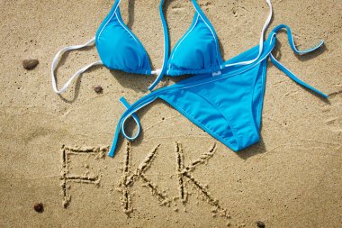 Çıplaklar plajı. Kumsalda kumsalda bikinili mayo. Doğabilimciler için plajı gösteren FKK öğretileri