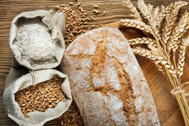 Ev yapımı somun ekmek ve ahşap masa malzemeleri.