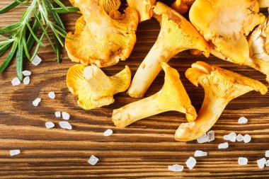 Sarı chanterelles ve ahşap masa üzerinde tuz kristalleri