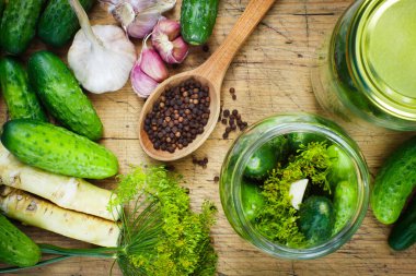 Tahtada sarımsaklı, dereotlu ve yabanturşulu ev yapımı turşu yapmak için hazırlıklar