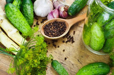 Tahtada sarımsaklı, dereotlu ve yabanturşulu ev yapımı turşu yapmak için hazırlıklar