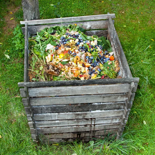 庭にビンを堆肥にしてください 腐敗した台所の果物や野菜のスクラップの山を構成する — ストック写真