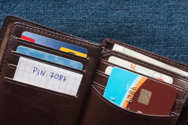 Mavi arka planda cüzdanında pin numarası olan kredi kartı