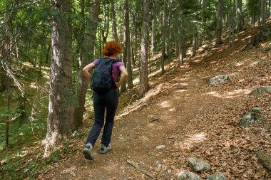 Dağlarda bir iz sırt ile kadın uzun yürüyüşe çıkan kimse