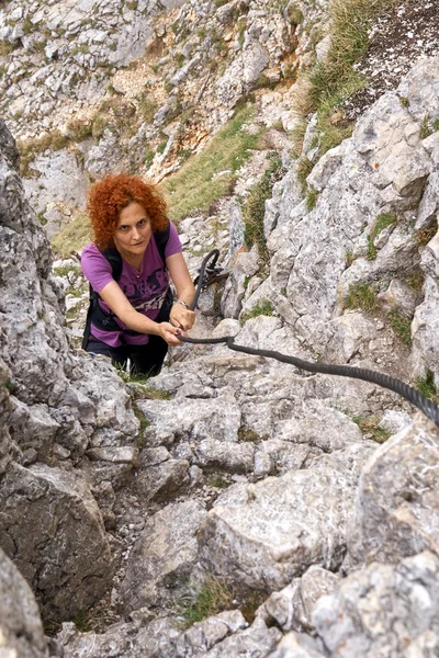 Woman free climbing on a via ferrata in the rocky mountains