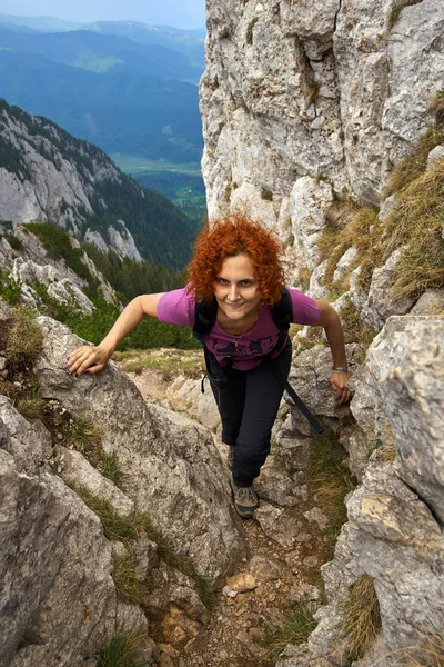 Woman free climbing on a via ferrata in the rocky mountains