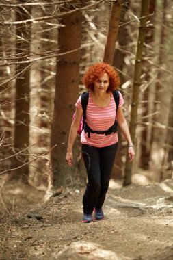 Dağlarda bir iz üzerinde hiking Kıvırcık Kızıl saçlı kadın