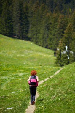 Dağlarda bir iz üzerinde hiking Kıvırcık Kızıl saçlı kadın