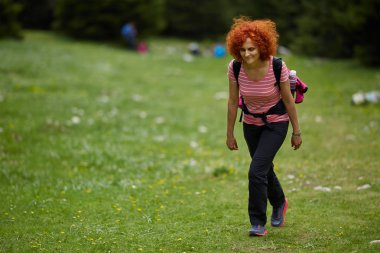 Dağlarda bir iz üzerinde hiking Kıvırcık Kızıl saçlı kadın