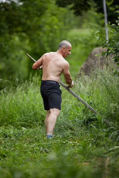 強いは 上半身裸の農民が土地を鎌で刈ることに合わせて — ストック写真