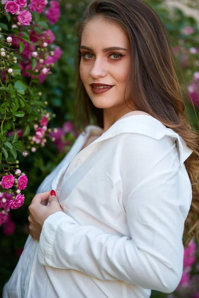 Closeup Mladá Usmívající Žena Bílých Šatech Poblíž Růže Bush Zahradě — Stock fotografie