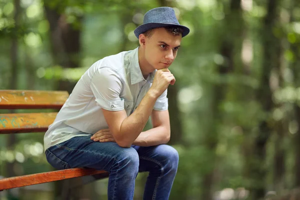 Συλλογισμένος Νεαρός Άνδρας Κάθεται Ένα Παγκάκι Στο Πάρκο — Φωτογραφία Αρχείου