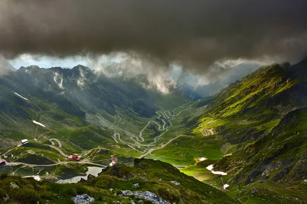 壮观的风景与山和蜿蜒的路在风暴之前日落 — 图库照片