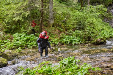 Çizmeler bir kız ile bir nehir taşıyan adam