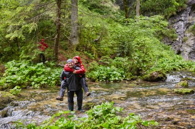 Çizmeler bir kız ile bir nehir taşıyan adam