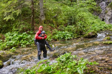 Çizmeler sırtımda bir çocuk Nehri üzerinde taşıyan adam