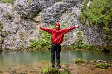 Yağmurluk karstik bir bahar tarafından mutlu beyaz adam