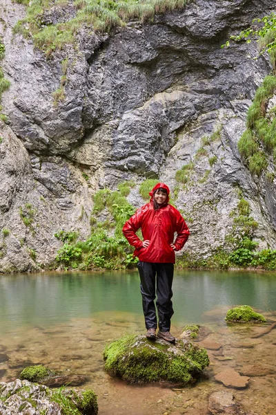 登山后的岩溶泉 穿雨衣的快乐女孩 — 图库照片