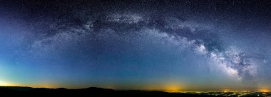 Samanyolu'nın Galaktik ark şehir ışıkları üzerinde panoramik çekim