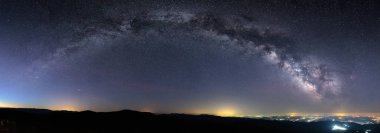 Samanyolu'nın Galaktik ark şehir ışıkları üzerinde panoramik çekim