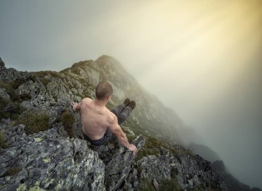 Muhteşem bir dağ manzarasında egzersiz yapan aktif bir adam.
