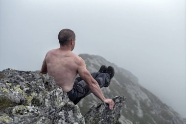 Muhteşem bir dağ manzarasında egzersiz yapan aktif bir adam.