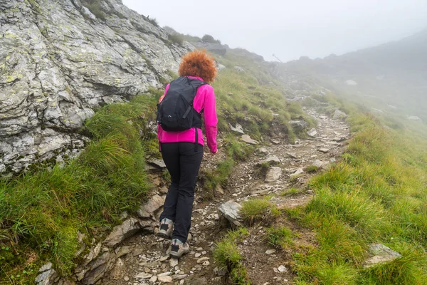 白人妇女徒步旅行者背着背包走在洛基山脉的小径上 — 图库照片