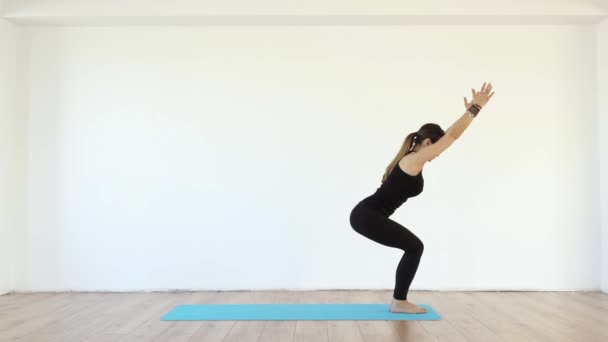 Young Female Yoga Teacher Studio Taking Various Poses White Wall — Stock Video