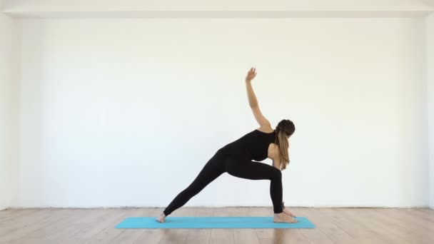 Young Female Yoga Teacher Studio Taking Various Poses White Wall — Stock Video