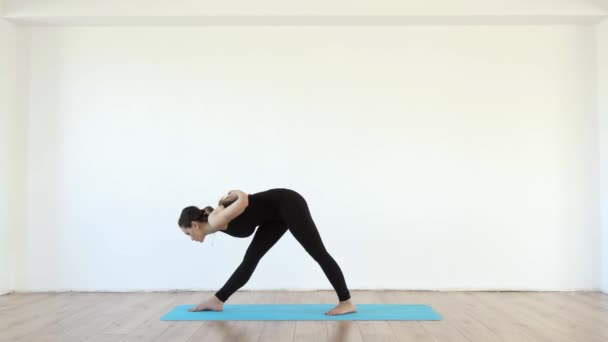 Young Female Yoga Teacher Studio Taking Various Poses White Wall — Stock Video