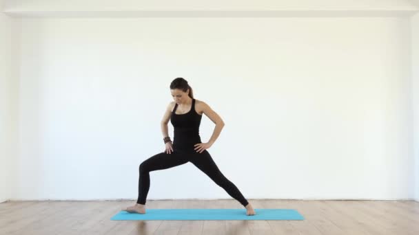 Junge Yogalehrerin Studio Nimmt Verschiedene Posen Auf Weißem Wandhintergrund Ein — Stockvideo