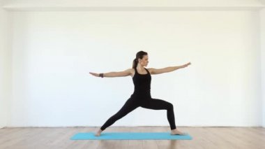 Genç kadın yoga öğretmeni Studio çeşitli pozlar beyaz duvar zemin üzerine alarak 