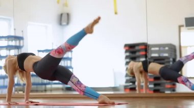 Genç kadın alarak çeşitli yoga yoga studio iç arka planda teşkil etmektedir. 