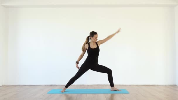 Young Female Yoga Teacher Studio Taking Various Poses White Wall — Stock Video