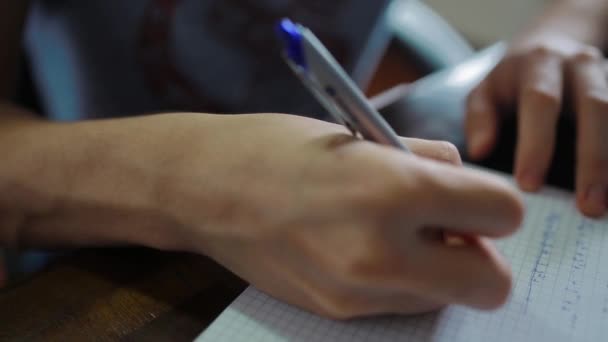 Nahaufnahme Eines Männlichen Schülers Der Hausaufgaben Ein Textbuch Schreibt — Stockvideo