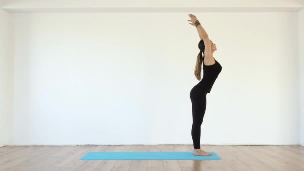 Young Female Yoga Teacher Studio Taking Various Poses White Wall — Stock Video