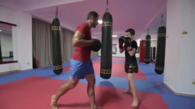 Spor salonunda antrenörü ile yastıkları isabet genç kickboks avcı
