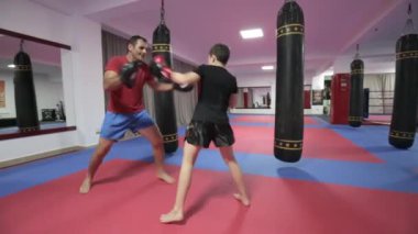 Spor salonunda antrenörü ile yastıkları isabet genç kickboks avcı